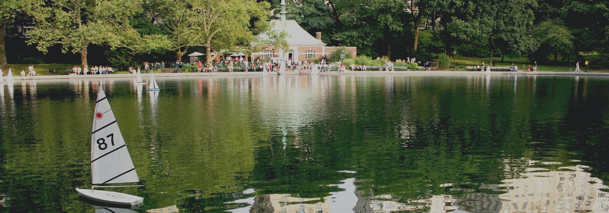 Small sailboat on the water with building in background